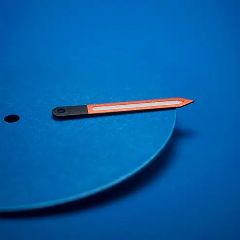 Bright orange and black watch hand displayed on a textured blue dial background.