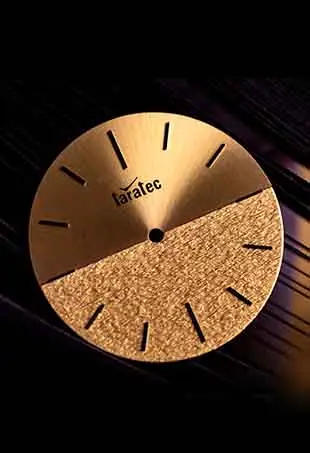 Gold watch dial with a brushed upper half and textured lower half