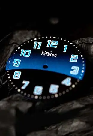 Bold black and blue gradient watch dial with large luminous Arabic numerals